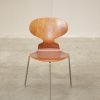 Mid-century modern chair: stylish wood seat with sleek metal legs.