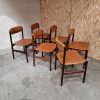 Mid-century modern rosewood dining chairs with leather seats.