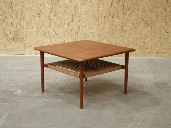 Mid-century modern teak coffee table with woven shelf.