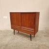 Mid-century modern teak cabinet with sliding doors and simple drawer handles.