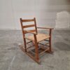 Rustic wooden rocking chair with woven seat.