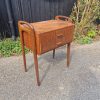 Vintage mid-century modern wooden cabinet with drawers and sleek, tapered legs.