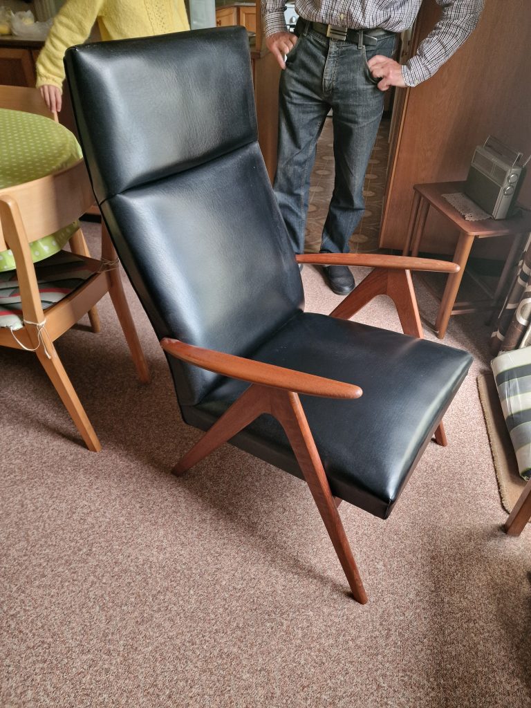 Lænestol med sort læder/skai og skrå ben og armlæn af massiv teak