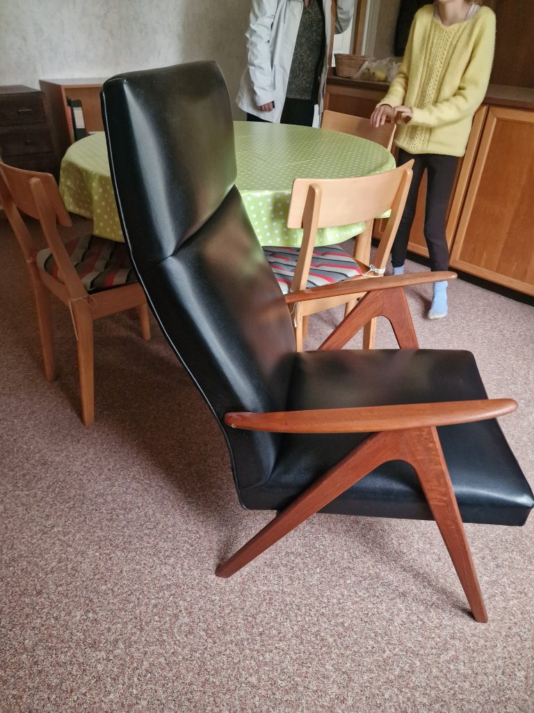 Lænestol med sort læder/skai og skrå ben og armlæn af massiv teak