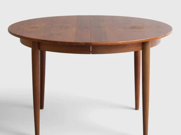 Cirkulært spisebord af palisander med runde tilspidsede ben, plade med udtræk og to medfølgende tillægsplader. Danmark, 1960’erne (1+2).